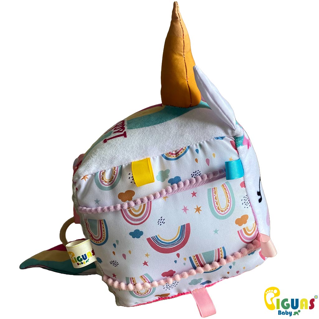 Un cubo sensorial para bebés con la cara de un unicornio aventurero, perfecto para estimular la vista, la audición y el tacto de tu bebé.