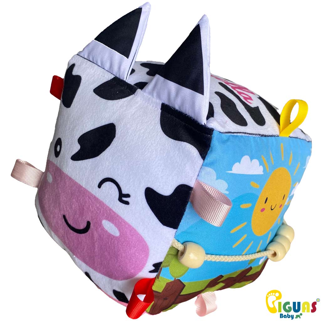 Un cubo sensorial con la cara de una vaca juguetona, perfecto para que tu bebé desarrolle sus habilidades jugando.