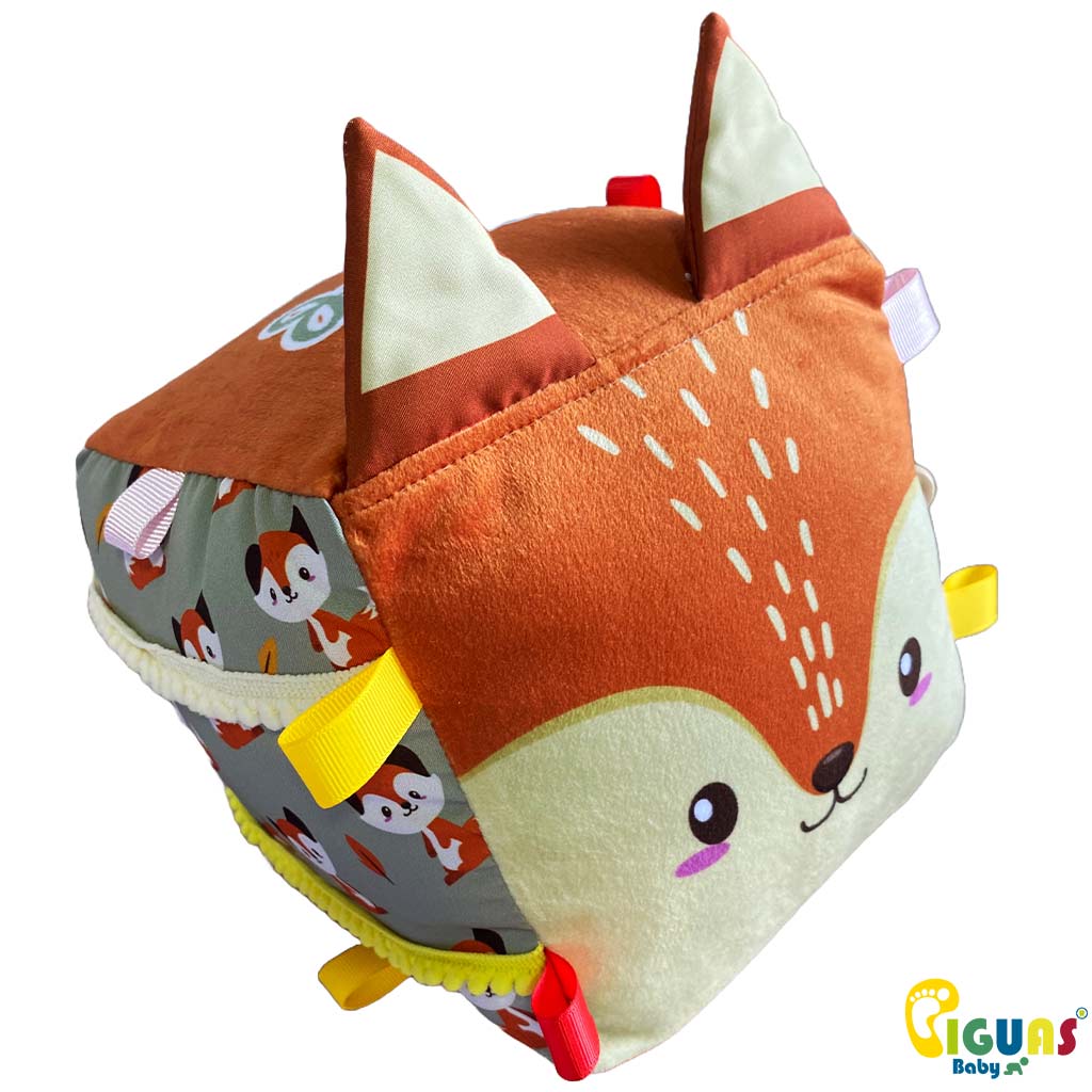 Un cubo sensorial para bebés con la cara de un zorro curioso, con texturas suaves y llamativas, perfecto para estimular el tacto y la vista de tu pequeño