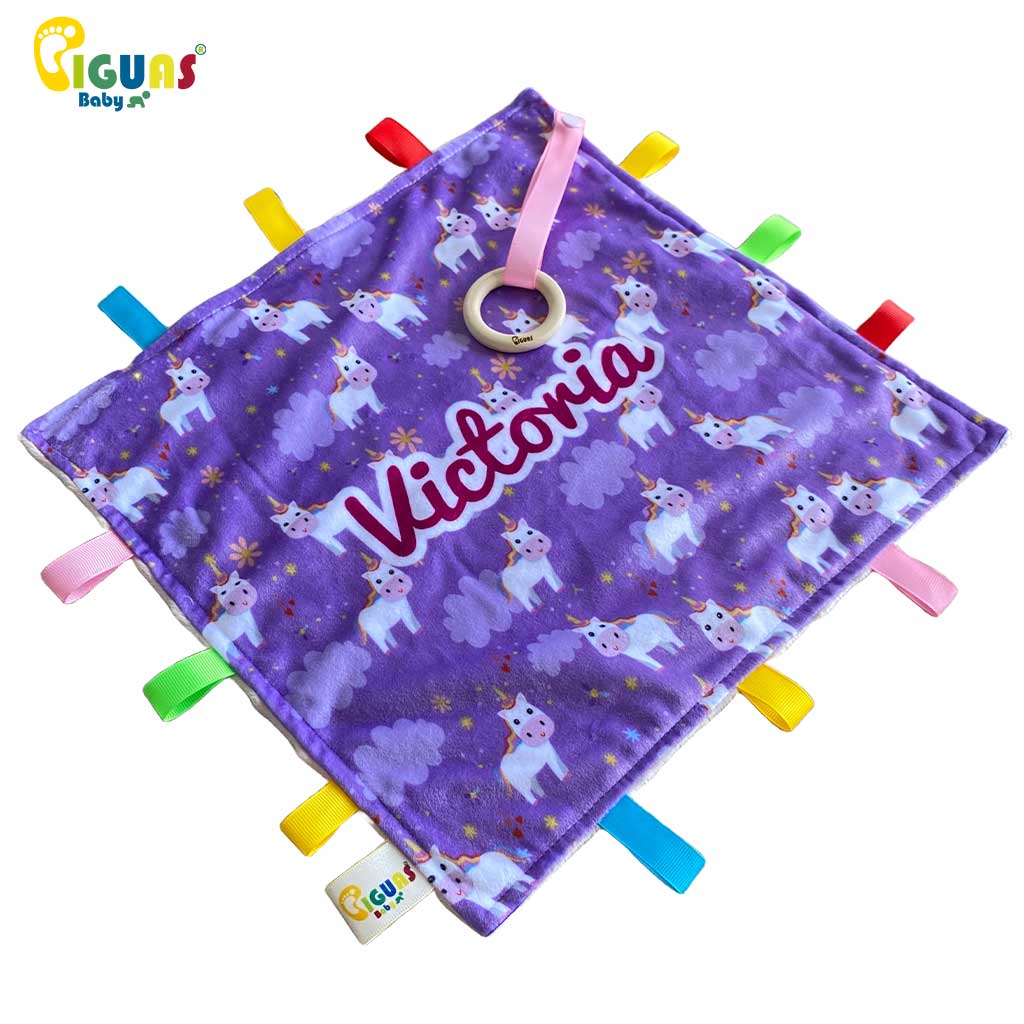 Mantita de apego para bebés suave con etiquetas de colores, ideal para la calma y el confort mientras juega con unicornios.