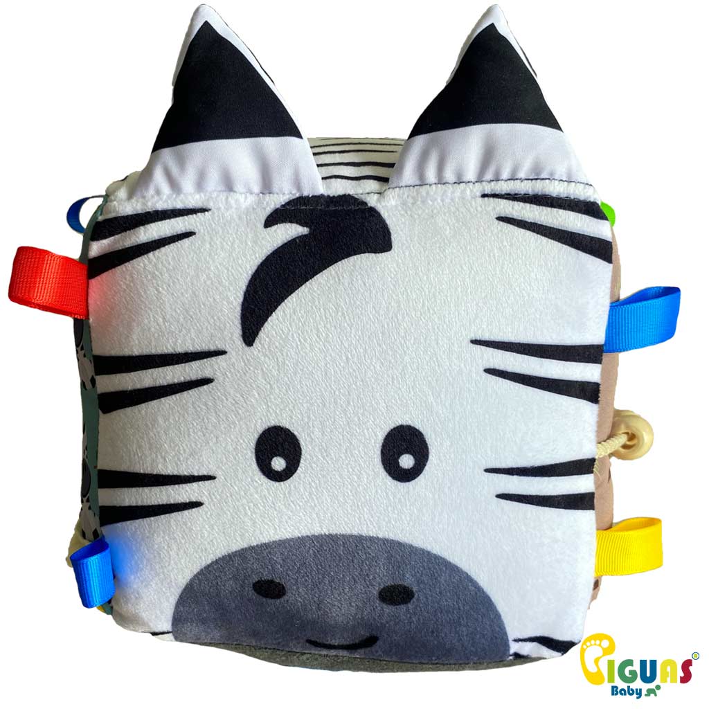 Un cubo sensorial para bebés con la cara de una cebra feliz, perfecto para estimular la atención de tu pequeño.