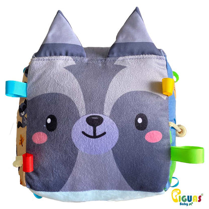 Un cubo sensorial para bebés con la cara de un mapache feliz, perfecto para estimular la atención de tu pequeño y ser su primer animalito