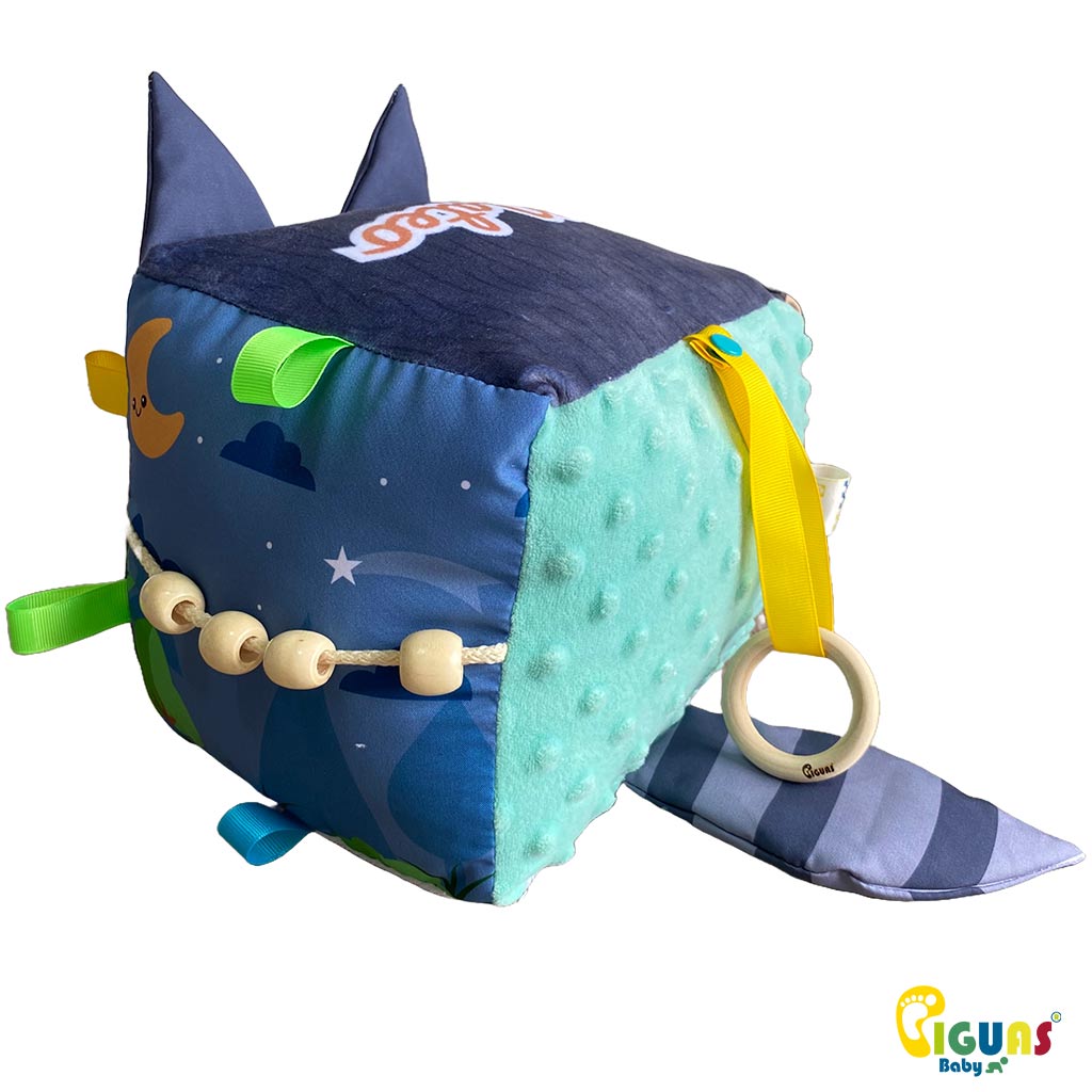 Cubo sensorial con forma cara del mapache más inteligente que emite sonidos al agitarlo al ser sonajero, y al agarrar sus orejas, al estar hechas con papel crujiente; ideal para el desarrollo auditivo del bebé. 